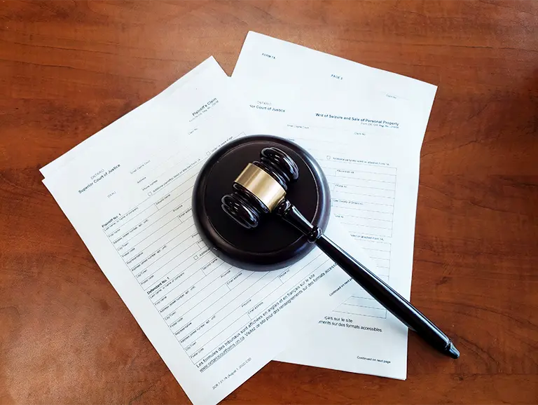 a gavel sitting on top of forms for small claims court